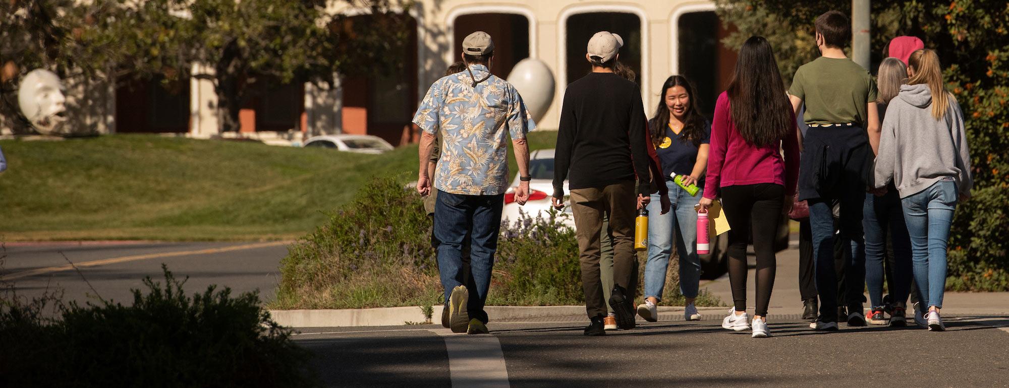 A female UC Davis student walks her audience through the UC Davis campus near Mrak Hall