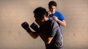 two students working out by boxing