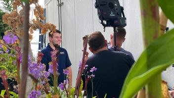 Jeremy working with the film crew at the Sciences Laboratory Building greenhouse.