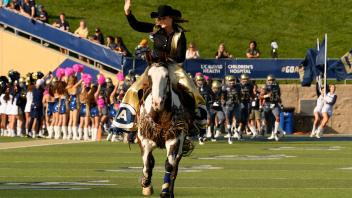Maggie the Aggie storms the football field mounted on her pony