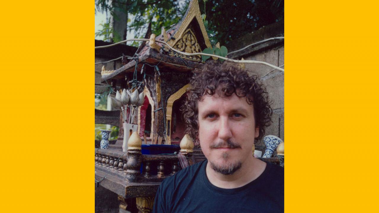 The author poses against backdrop of a small temple.