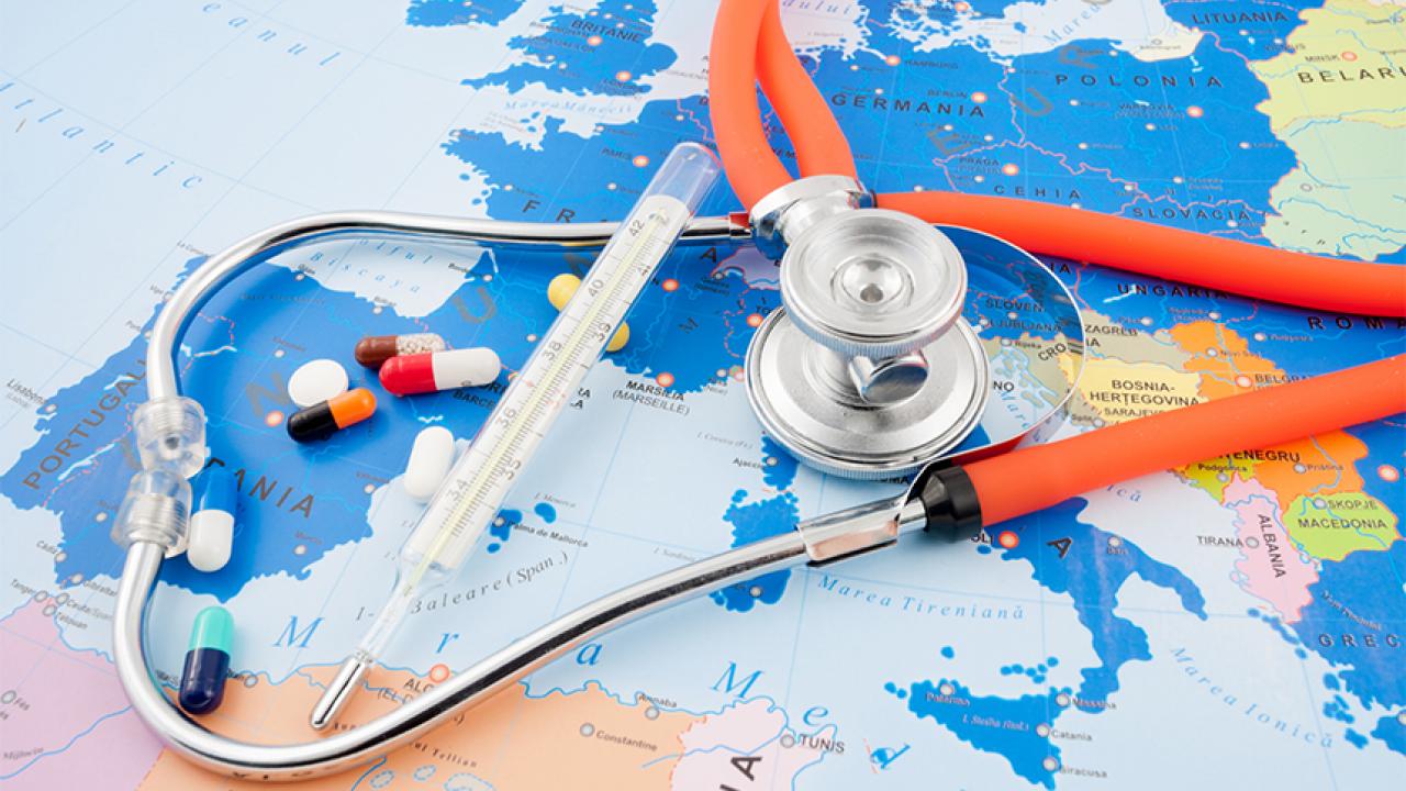 A thermometer, stethoscope, and pills on a map of Europe