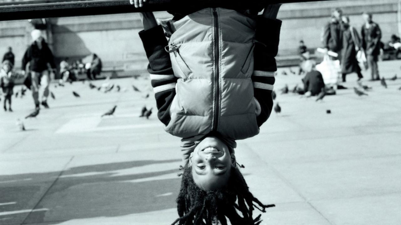 Child hangs upside down from outdoor play equipment, cropped from book cover.