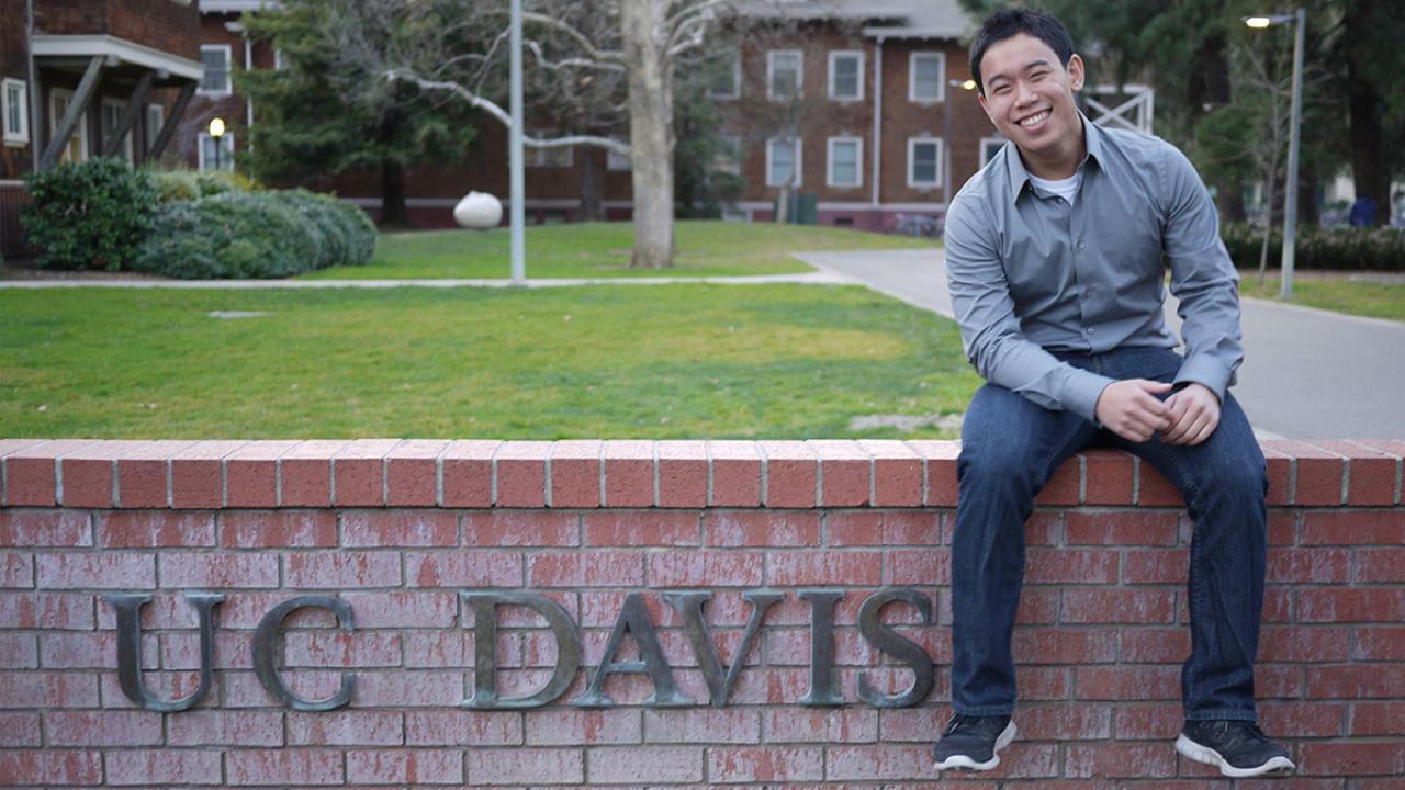 Communication major Chinsin Sim sitting on the East UC Davis Wall