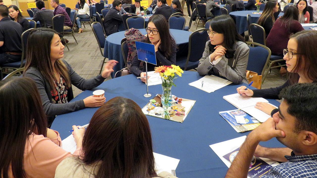Wendy Chen &rsquo;17 (gesturing on left) to a table of students about being a consultant