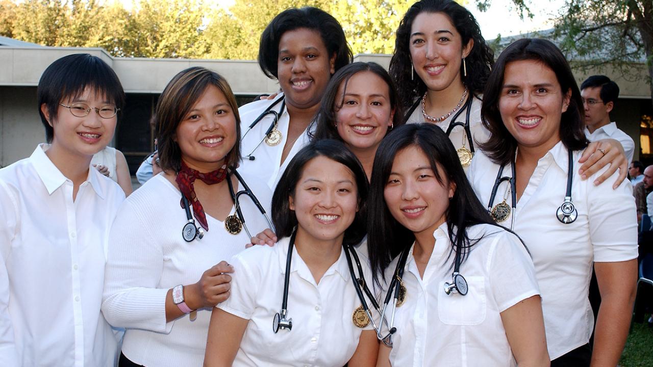 A group of entering medical students (women) with stethoscopes posting together 