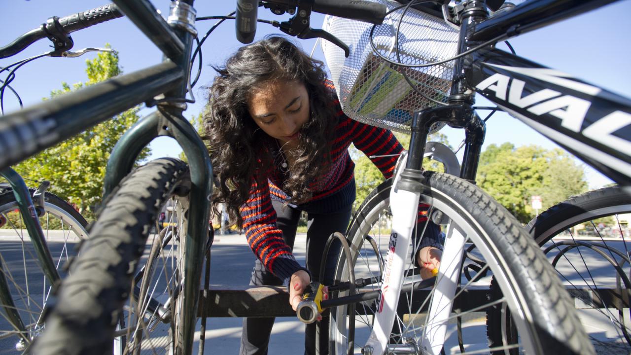 UC Davis student Sidra Ali locks up her bicycle.
