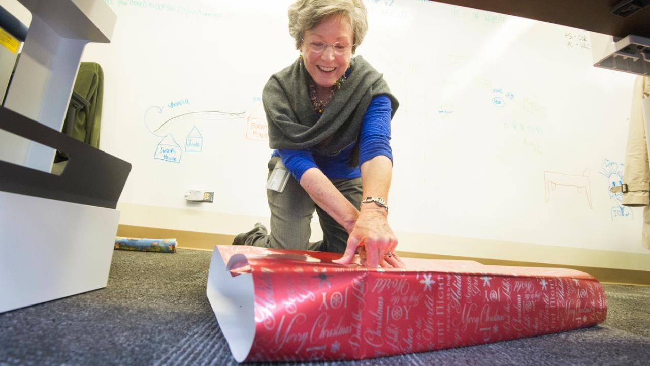 Jo Anne Boorkman, of Academic Affairs, wraps a gift collected for STEAC in 2014.