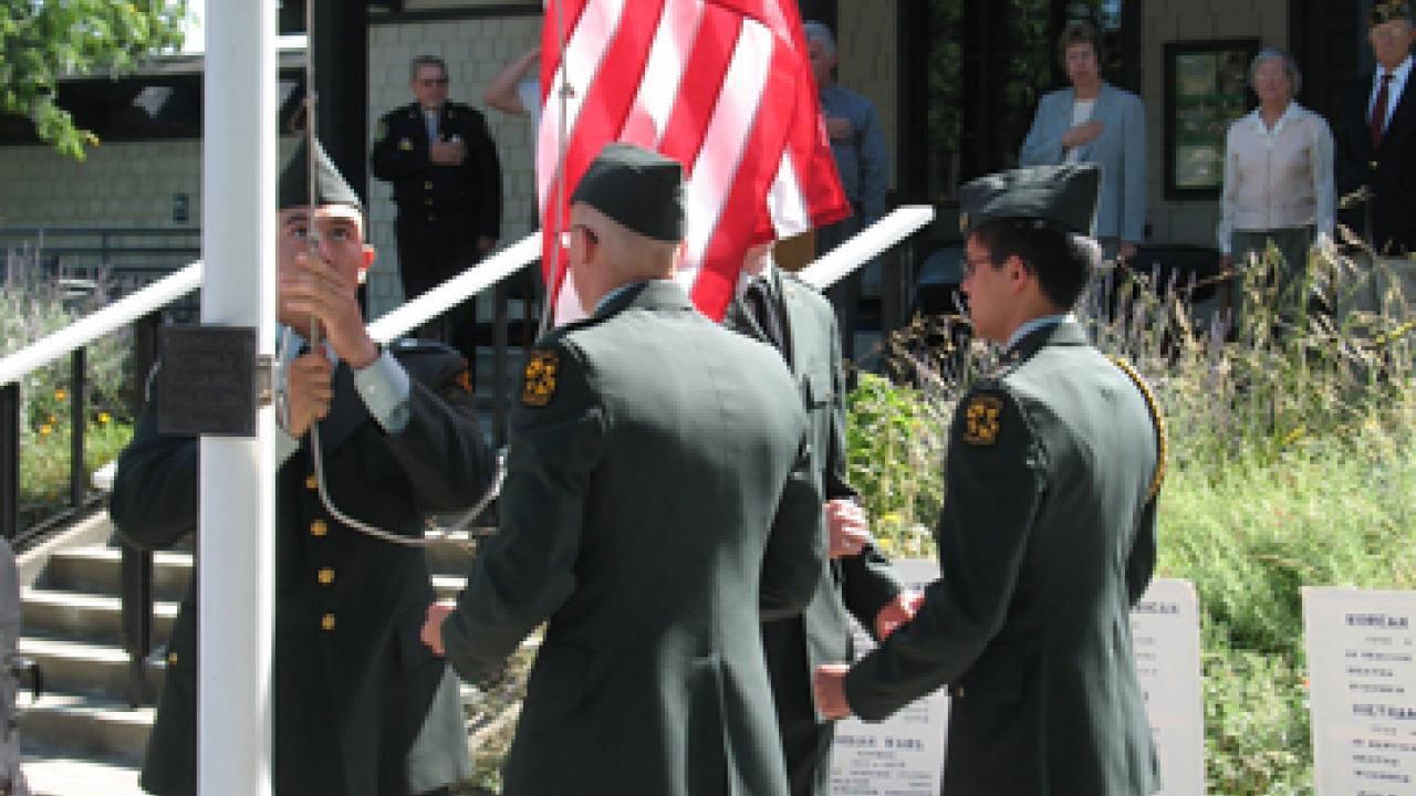 UC Davis Army ROTC color guard raises the Stars and Stripes at the Memorial Day observance at Davis Cemetery.