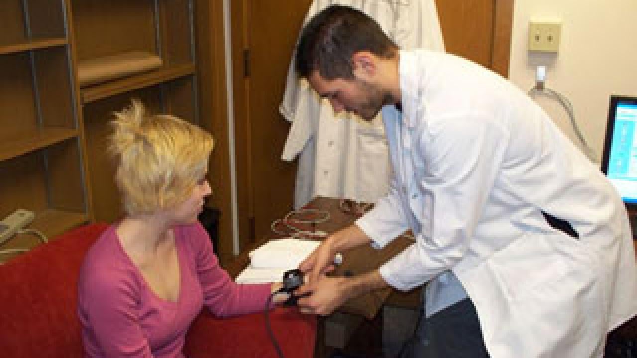 UC Davis Psychologist Jonathan Helm and a student set up machinery to study heart rates and respiration in romantic couples