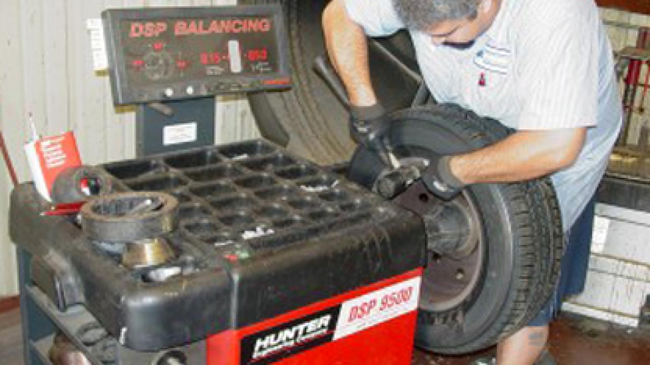 Photo: Manny Souza, automotive technician assistant with Fleet Services, installs a steel wheel weight.