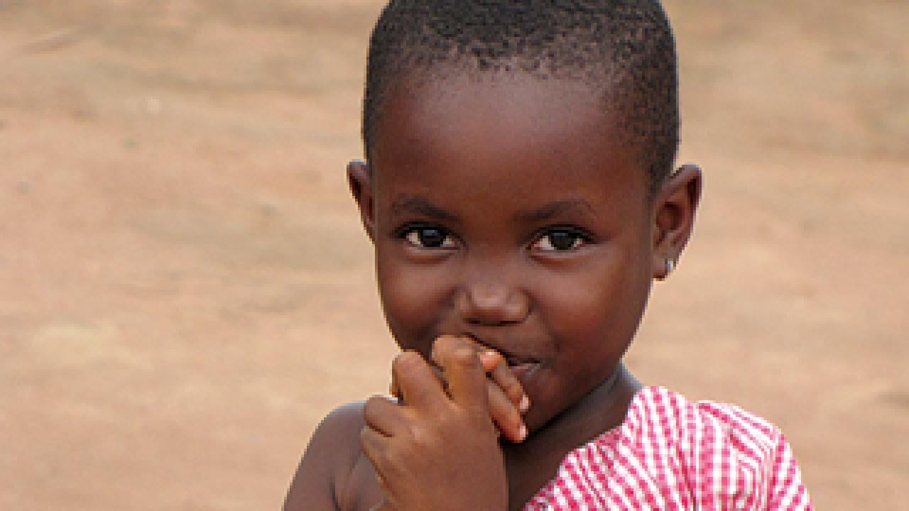 Young African girl with hands to lips