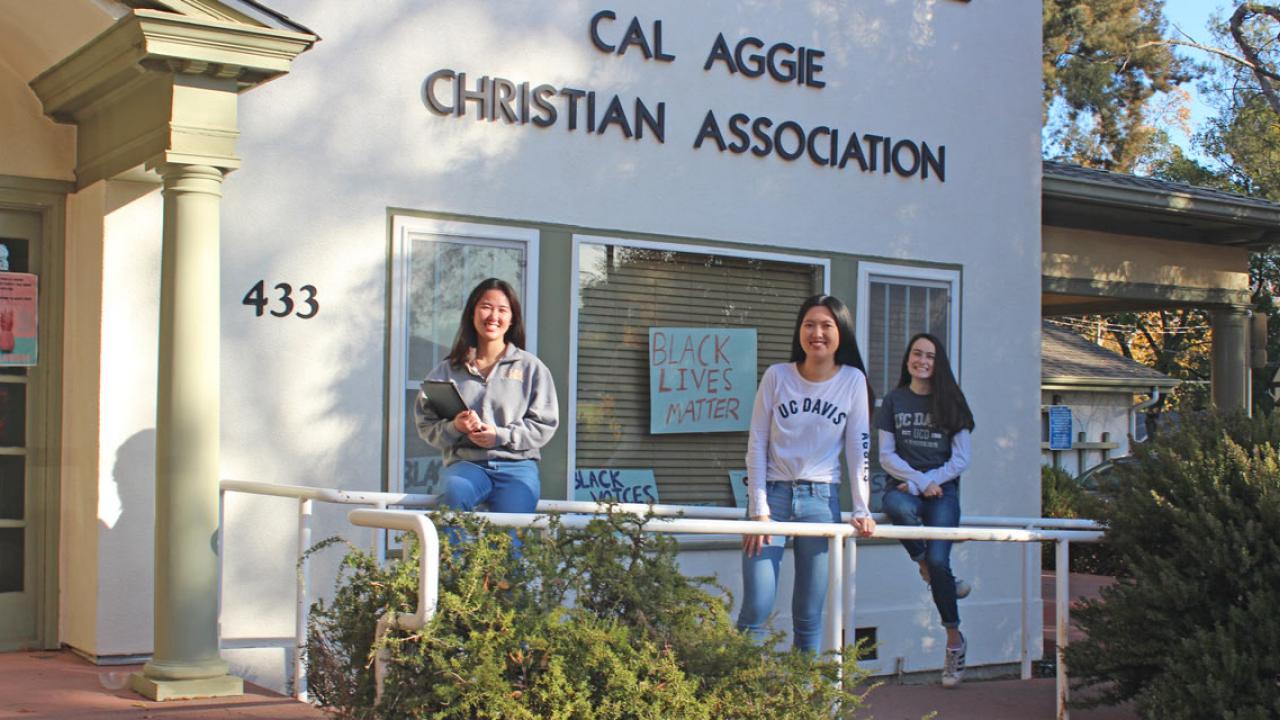 Three women pose on front porch of Cal Aggie Christian Association house.