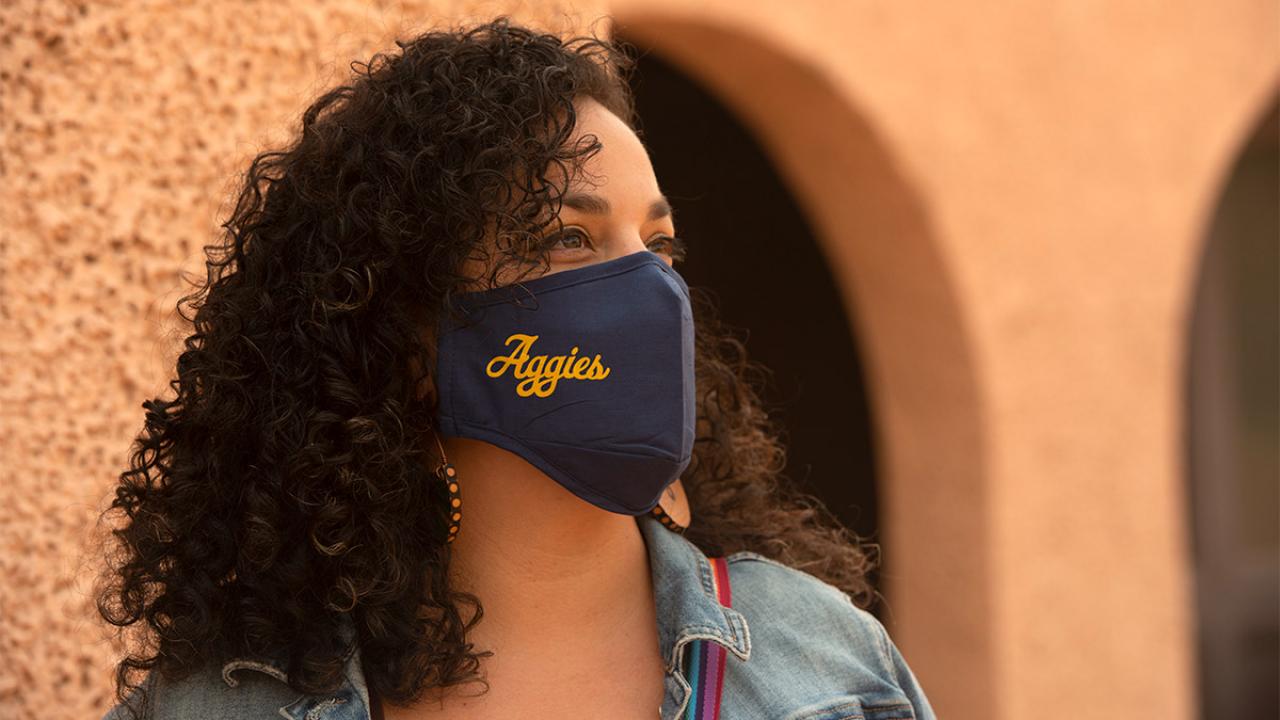 Woman wearing Aggies-branded face covering.