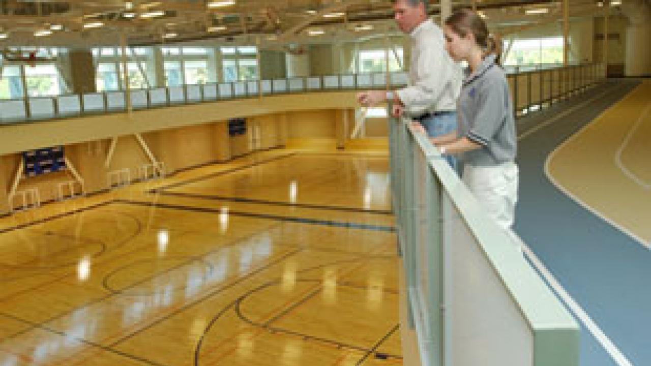 Rec Hall director Jim Rodems and student Rebecca Miller stand along a meandering track, surveying the main gym area inside the ARC.