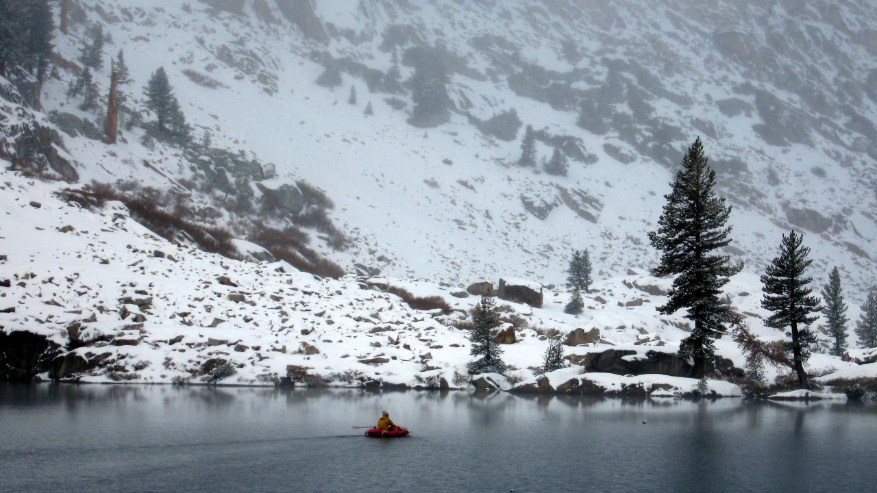 Scientist in boat on Emerald Lake during winter
