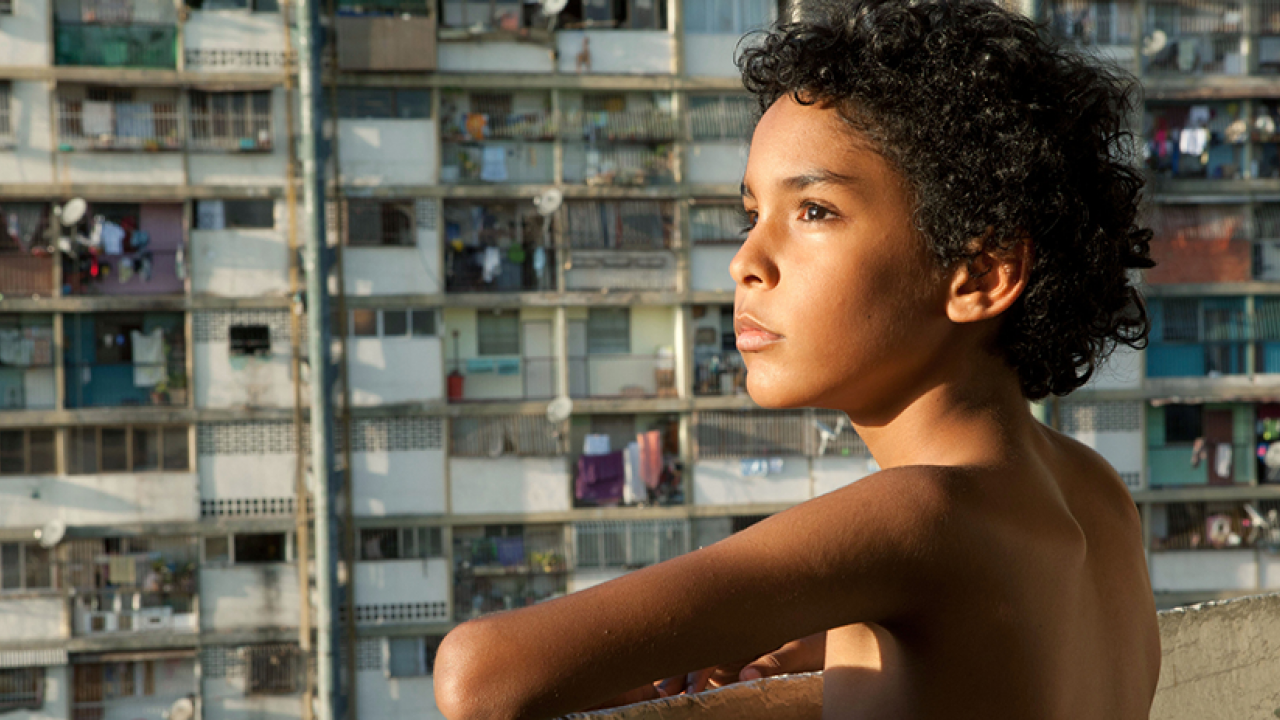 Boy with curly hair, on balcony