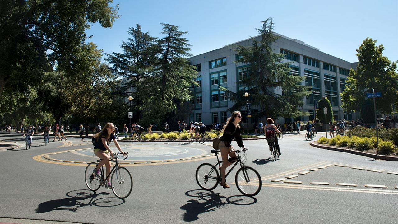 Students ride bicycles in a bike circle.