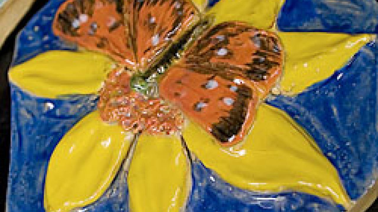 Photo: Tile showing a butterfly on top of a flower