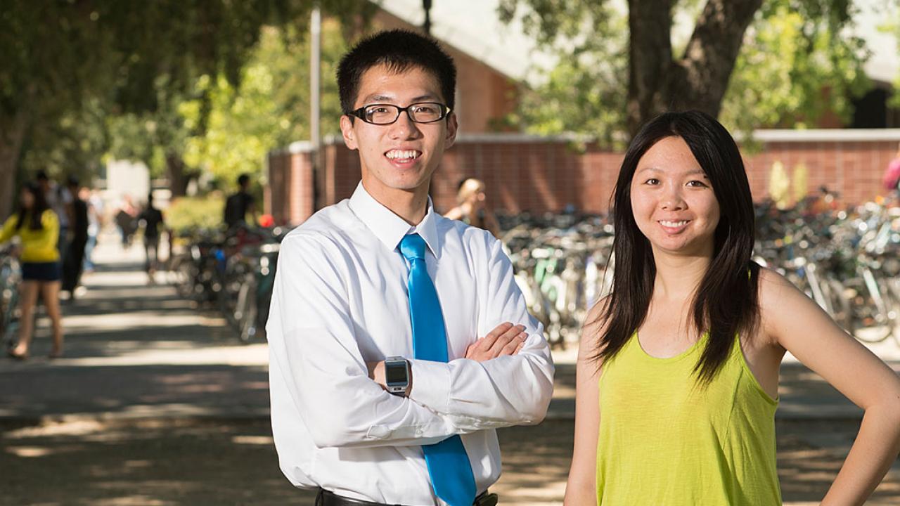 Man in white shirt and tie and woman in sleeveless blouse poising on the UC Davis campus