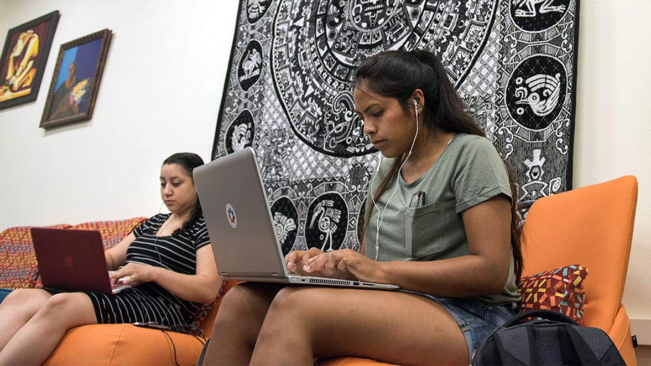 Students study while on a couch.