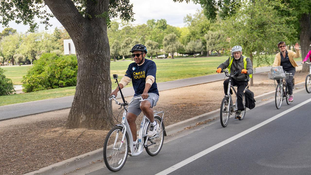 Chancellor Gary S. May riding a bicycle.
