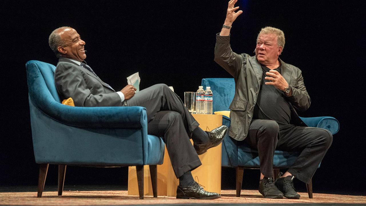 Chancellor Gary S. May laughs as William Shatner gestures.