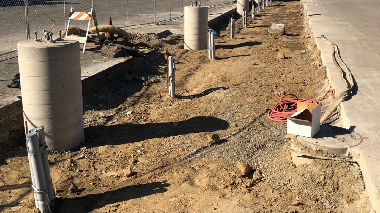 Conduit sticks out of ground for future charging stations.