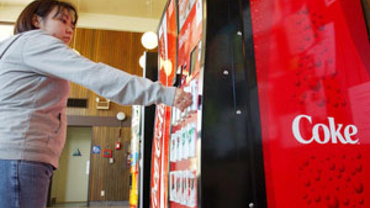 Student Taeko Aoki makes her selection at one of the campus's 130 vending machines, which last year dispensed some 500,000 sodas.  