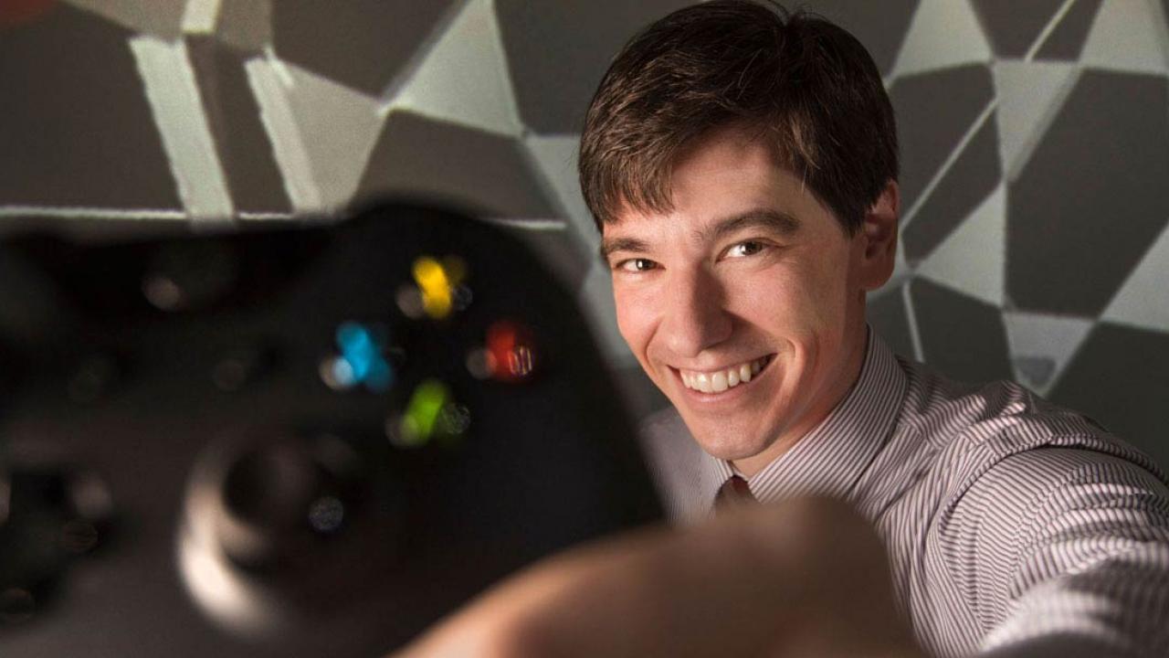 Colin Milburn holds a video game console