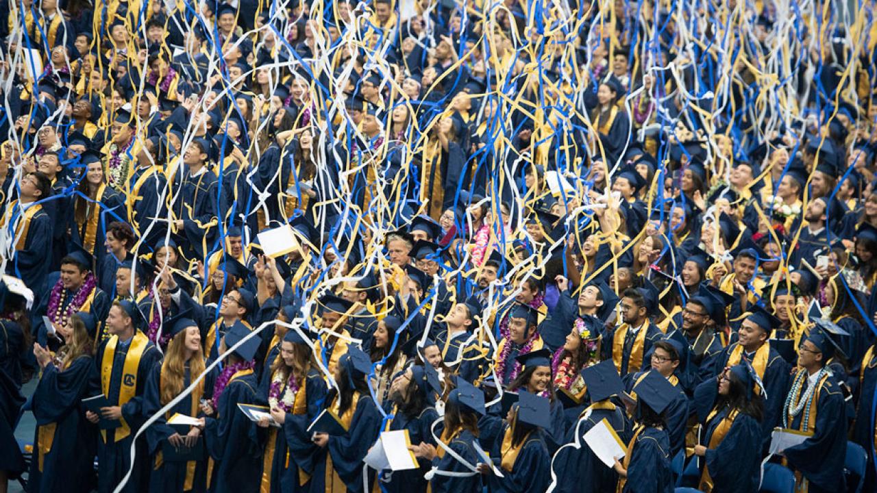 Blue and gold streamers falling on graduates.