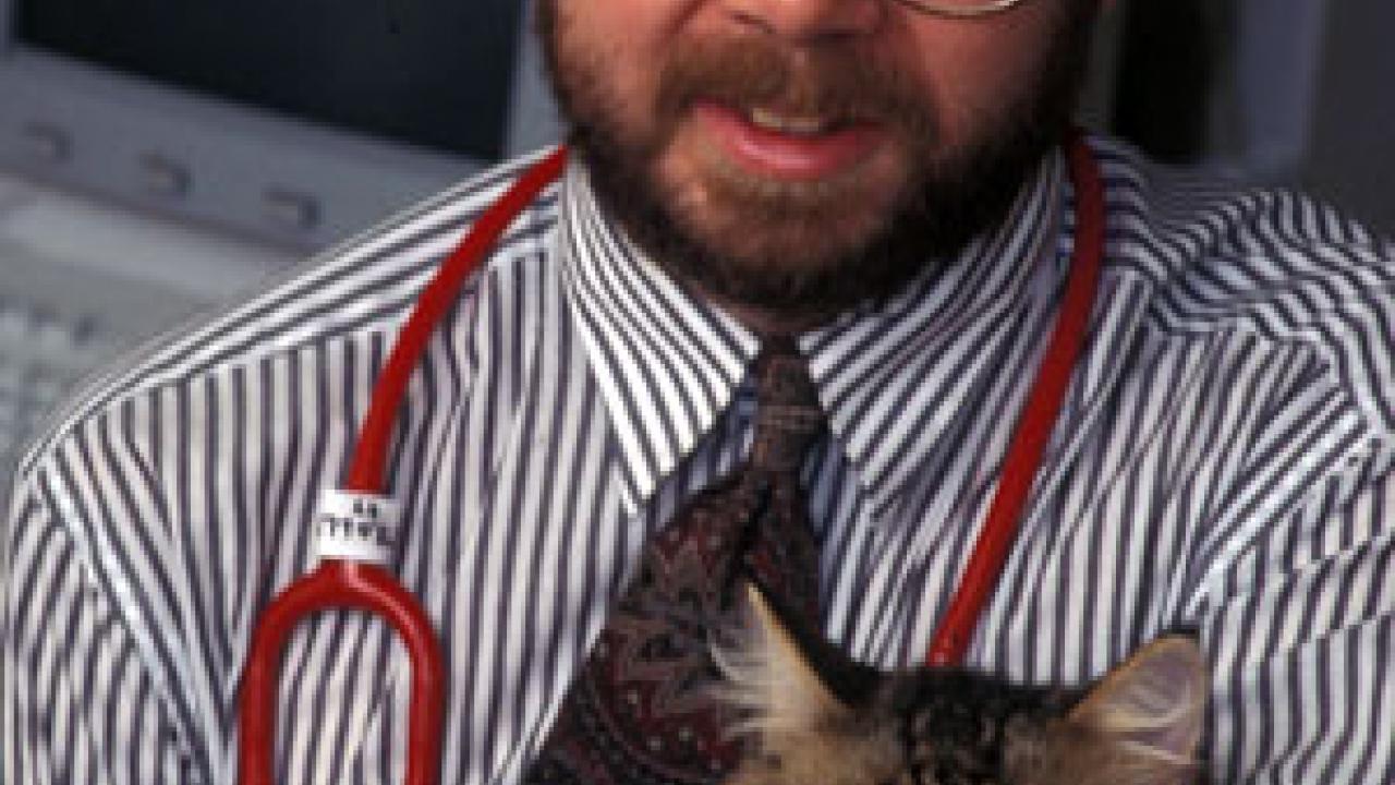 Photo: Man with stethoscope cuddling cat
