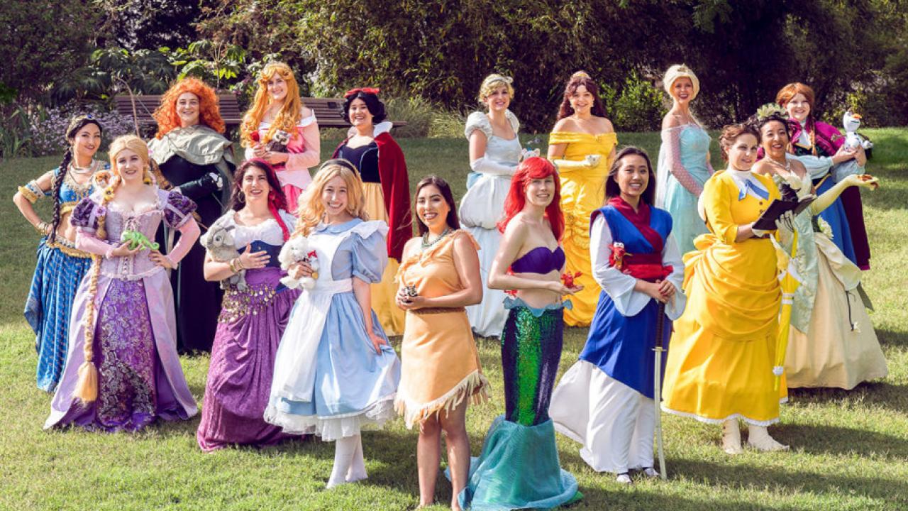 Fifteen women in coloful costumes