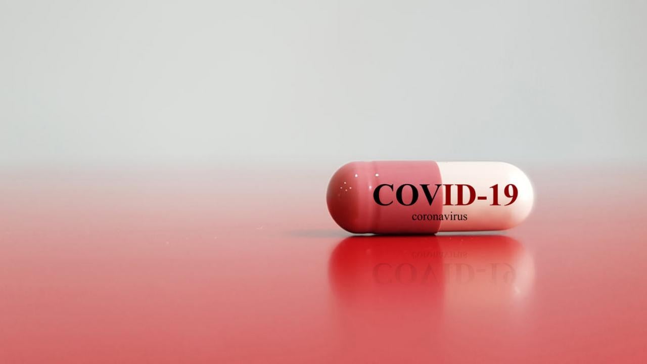 An Rx capsule labeled "COVID-19 Coronavirus"