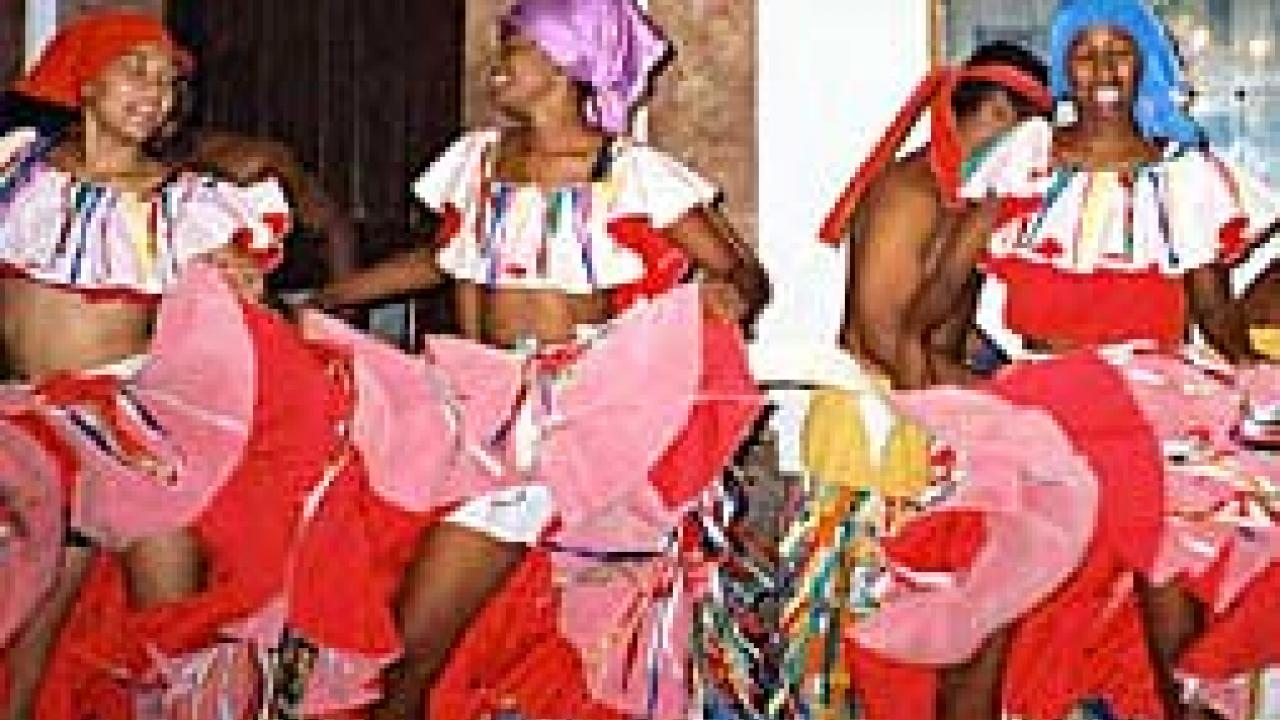 Photo: Three women in costume dancing, holding skirts up