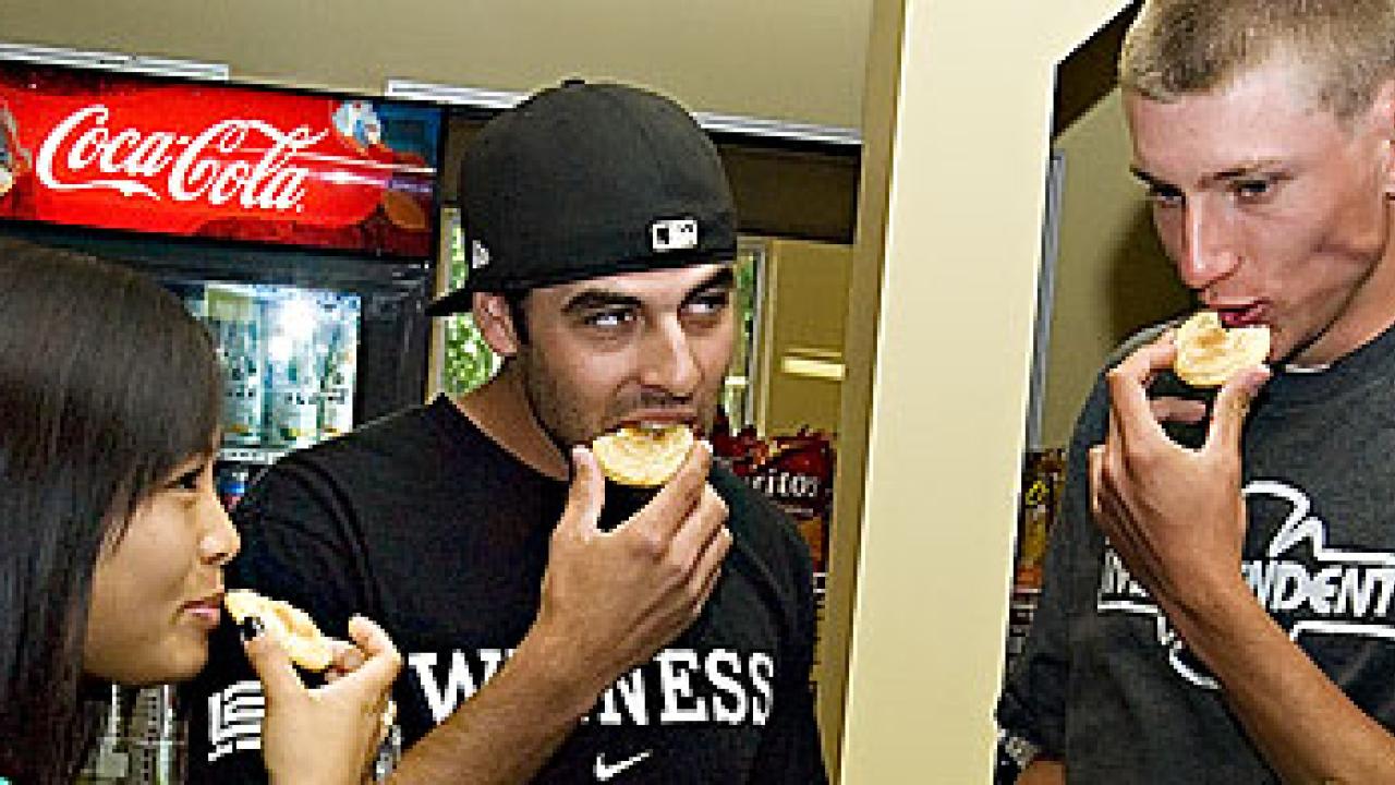 Photo: Marie Lee, Scot Heylman and Tj Copple eat a cookie.
