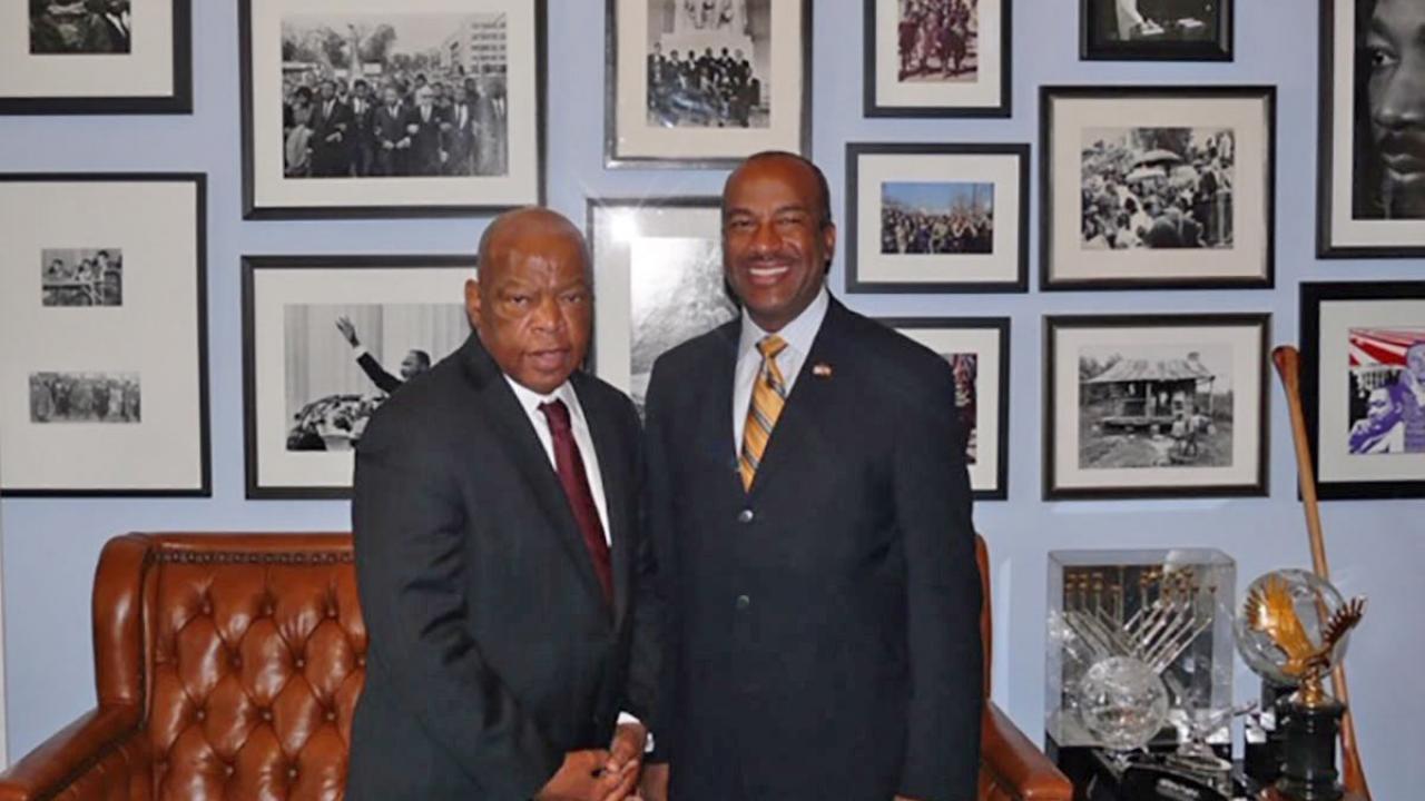 Rep. John Lewis and Chancellor Gary S. May, in posed photo against wall of photos.