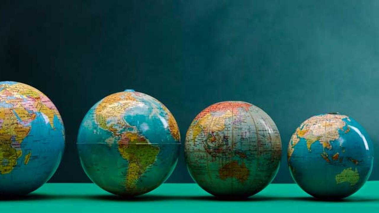 Five different-sized globes of the world.
