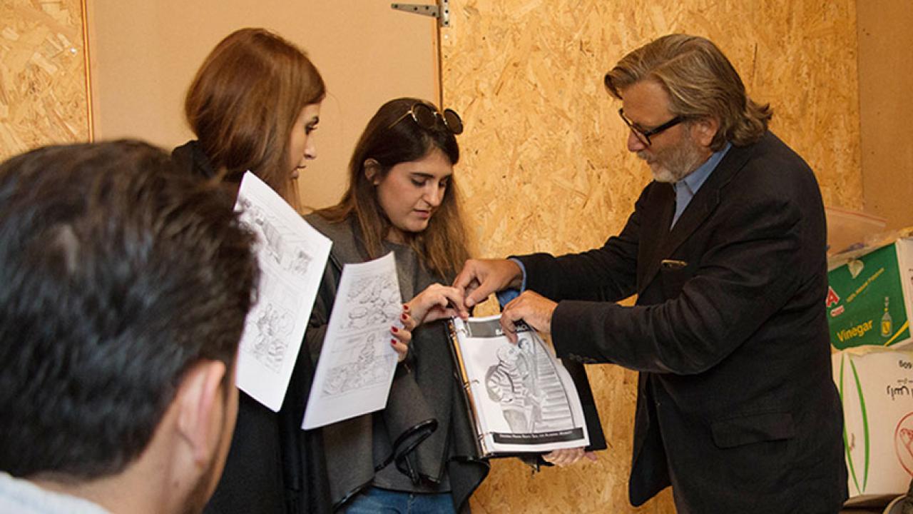 Professor Keith David Watenpaugh and two American University in Beirut use a comic book to explain Article 26 Backpack