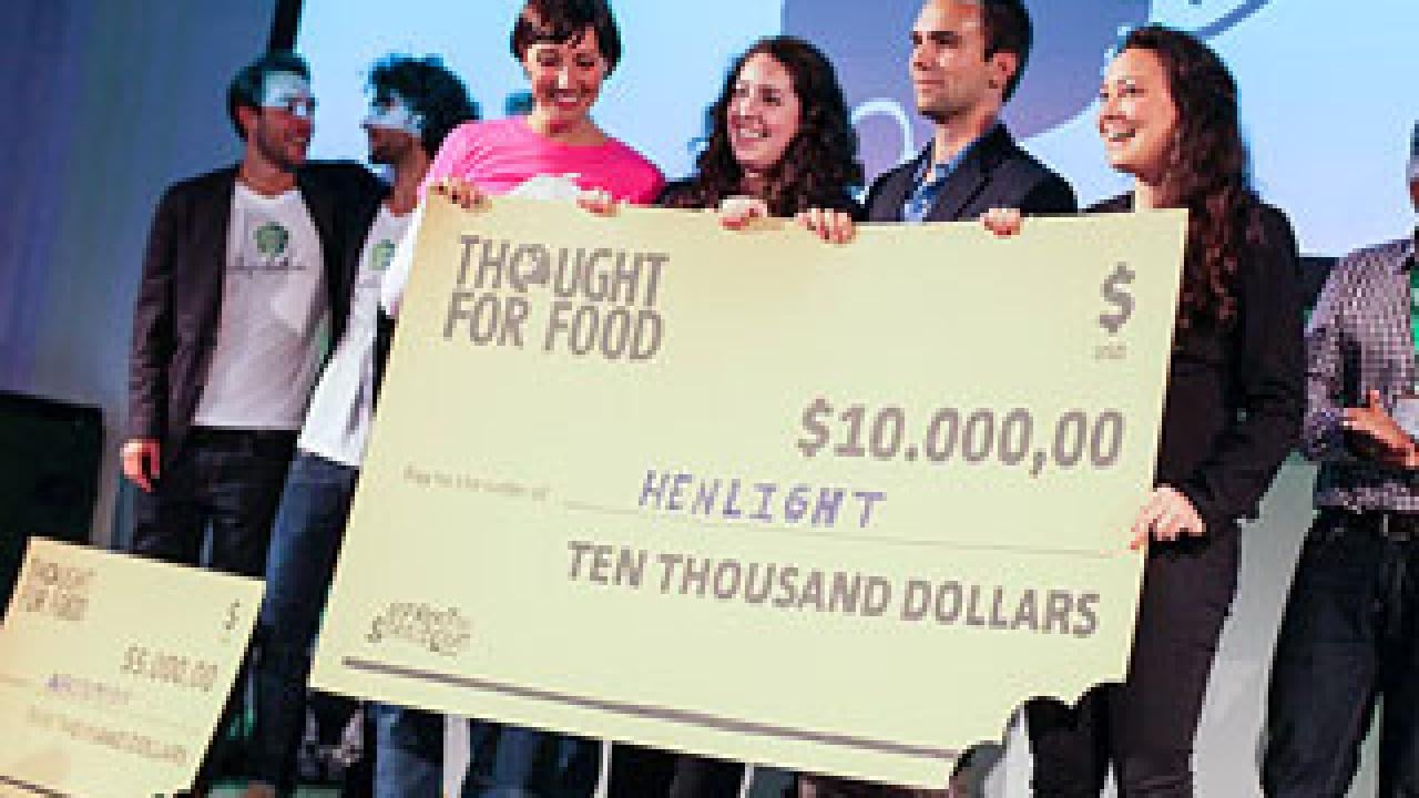 Photo: Four people holding a big "check" for $10,000 while posing for a picture.