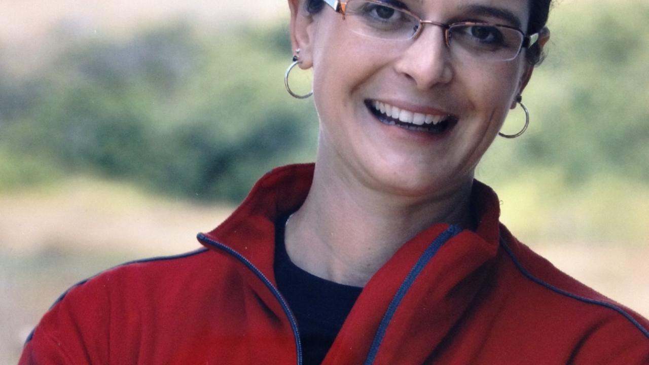 Female scientist in red jacket.