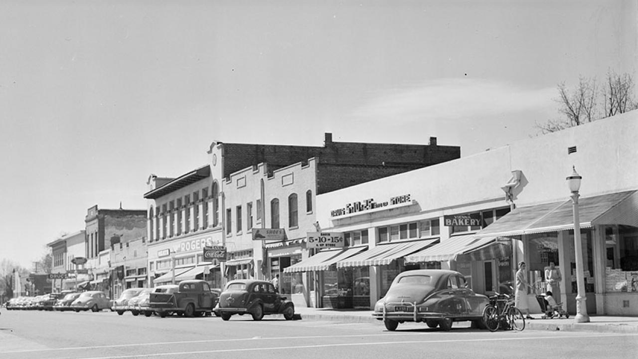 A 1951 photo looking south on G Street in Davis shows shops and vehicles. 