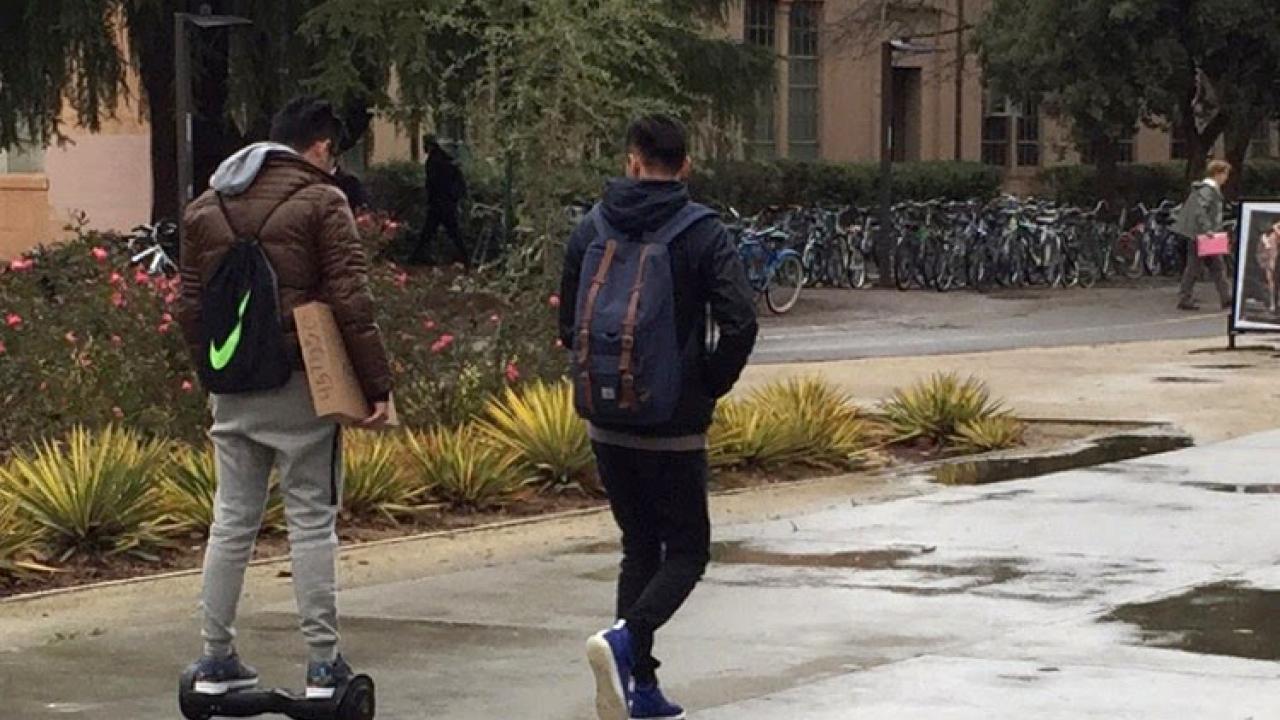 A student rides a hoverboard near Shields Library.