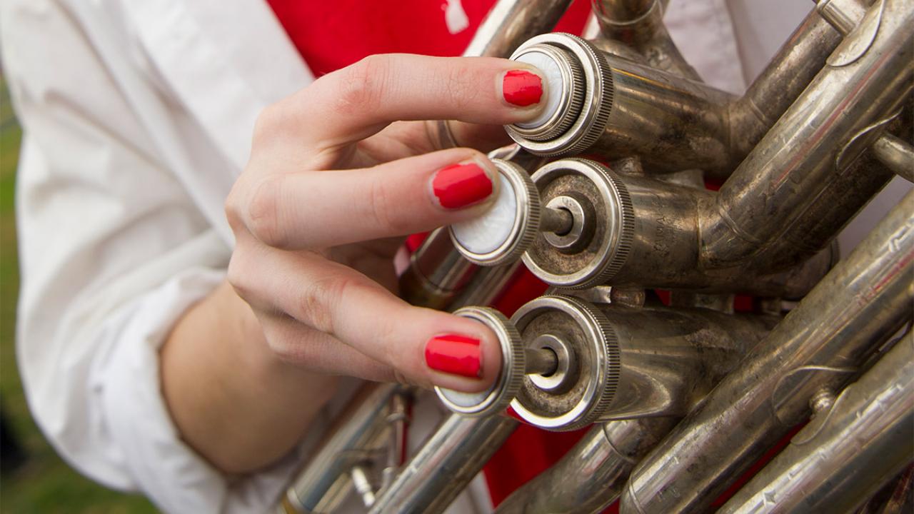 A close-up photo of the hands playing an instrument.