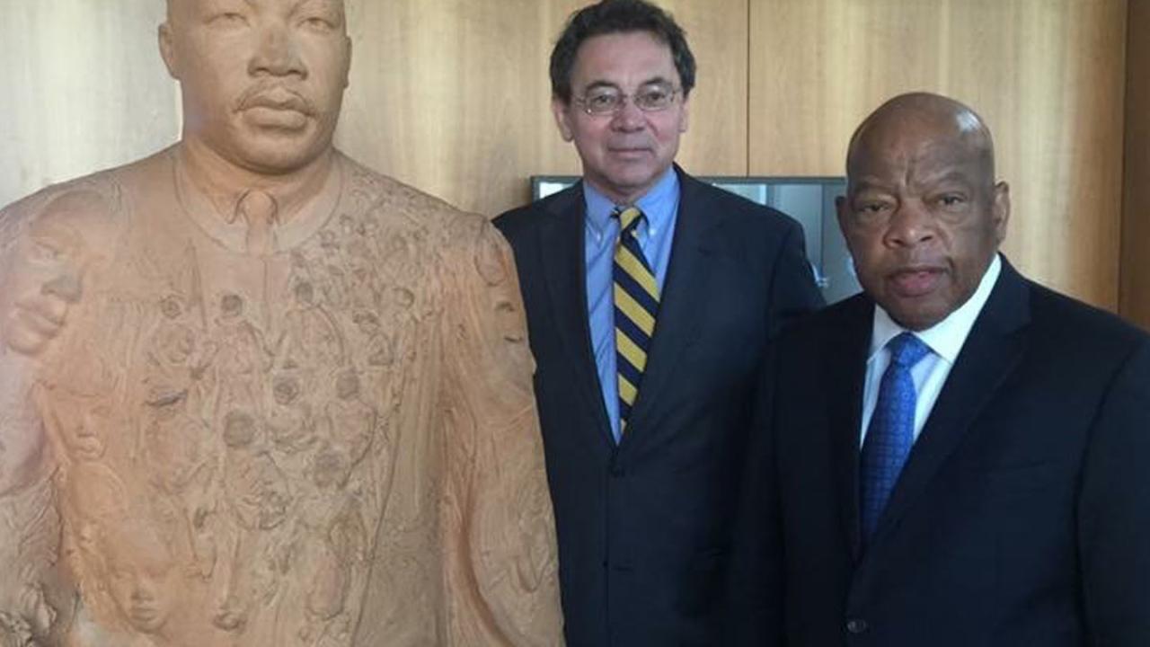 Two men pose with statue of Martin Luther King Jr.