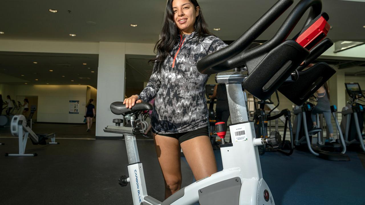 Karina Montoya poses with a staionary bicycle.