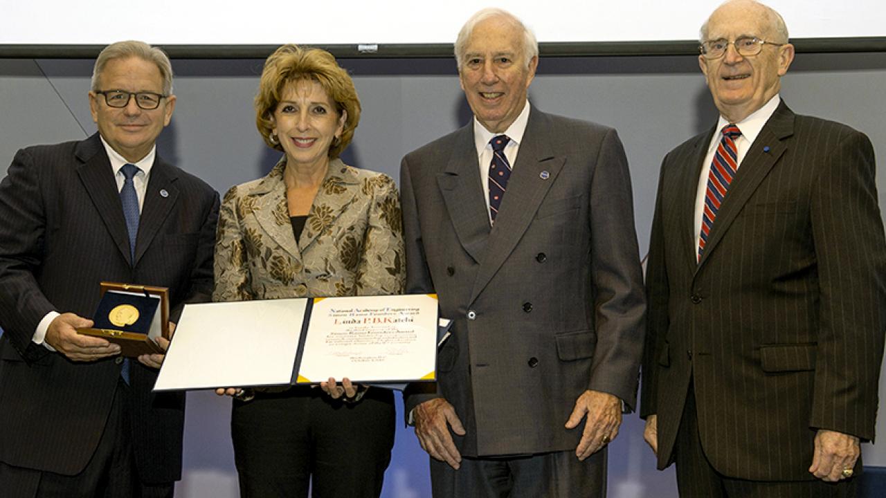 Photo: Chancellor Katehi holds certificate, while one of three other dignitaries holds medal.