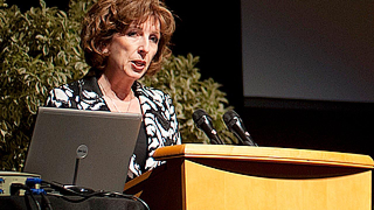 Standing at a podium, Chancellor Linda Katehi shows her resolve to rally forces for policy and research breakthroughs