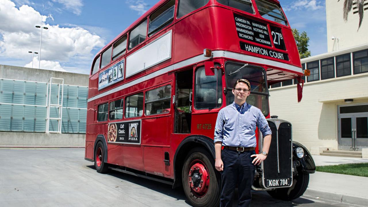 Photo: Lars Reed stands in front of one of Unitrans' historic double-decker buses.