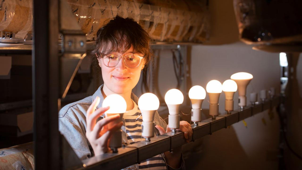 Woman installs an LED bulb. 